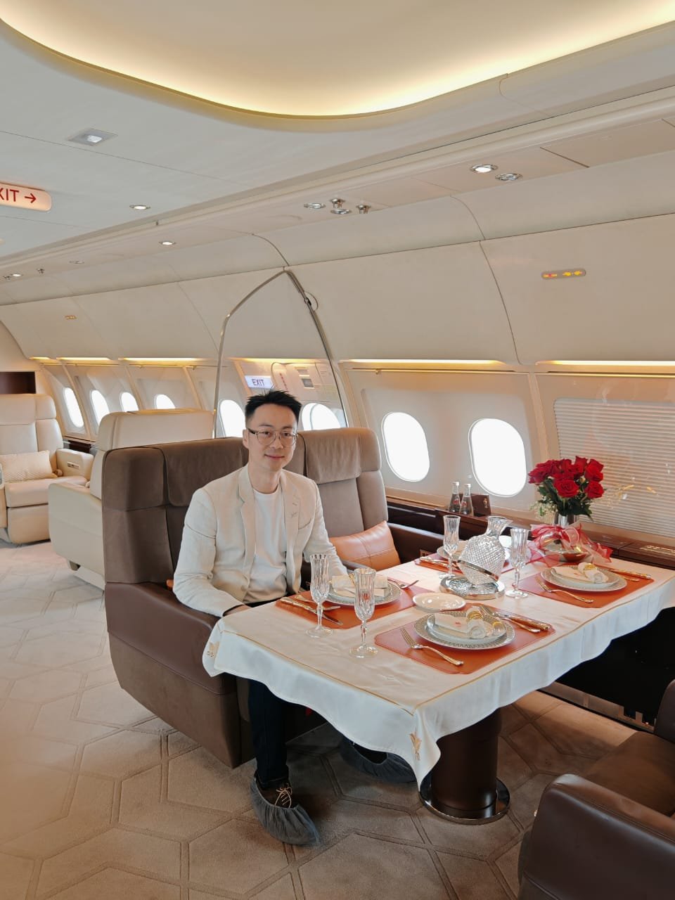 Marcus Teoh seated at the dining table inside an Airbus ACJ318 business jet